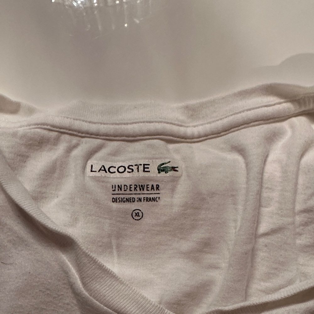 Selected 5 Ts for $22. Lacoste White Undershirt with Logo. Needs to be washed.